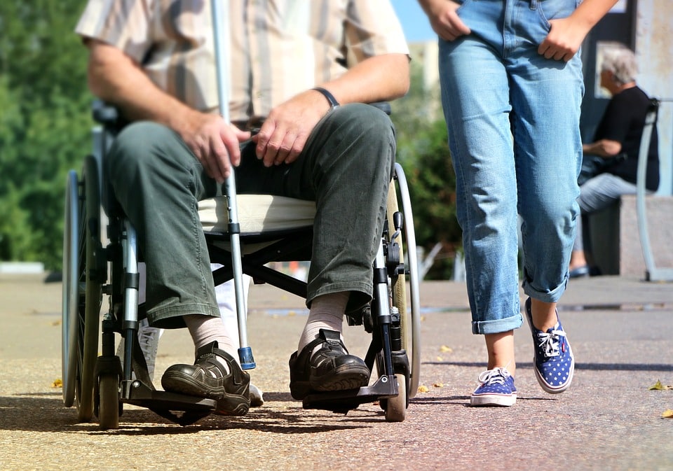 Personne en fauteuil roulant qui se déplace sur un trottoir